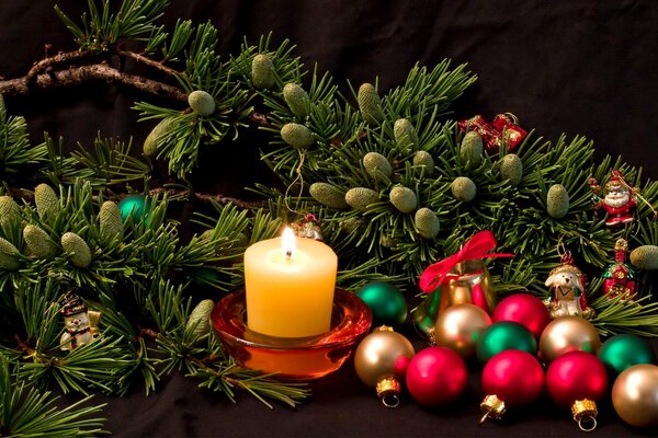 Bodegón de año nuevo de velas, ramas de árboles de Navidad y juguetes
