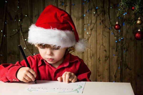 Ein Junge, der einen Brief an den Weihnachtsmann schreibt