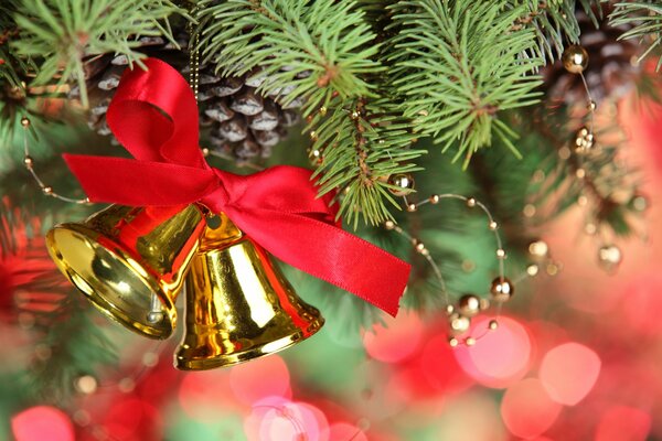 Decoración campanas de oro con arco rojo en el árbol de Navidad