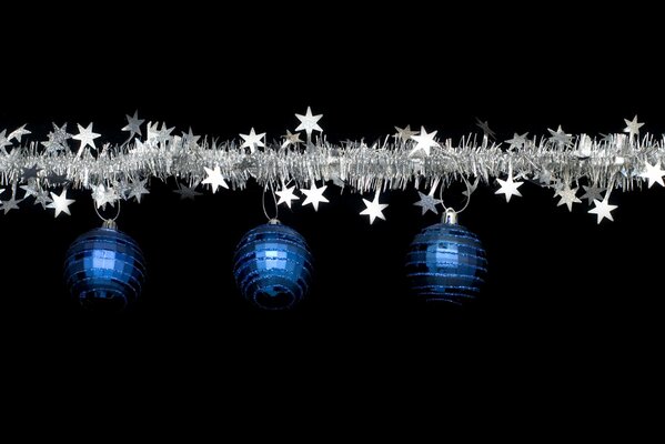 A garland of tinsel with snowflakes and blue balls