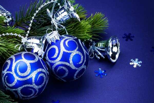 Deux boules bleues de Noël avec des boucles d argent sur une branche d épinette