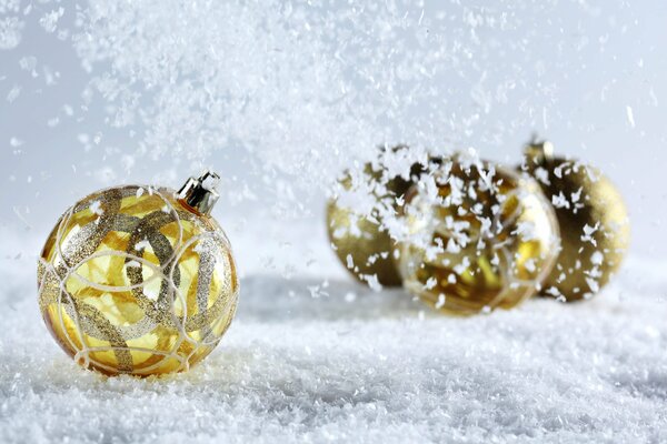 Złote bombki na śniegu