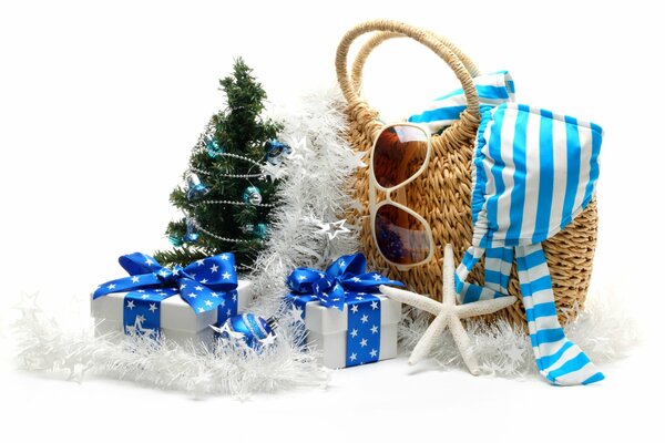 A Christmas tree with gifts and a bag with a swimsuit and glasses