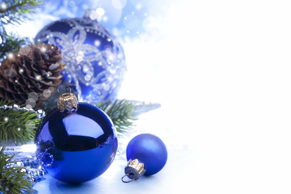 Christmas balls near a pine branch with a cone