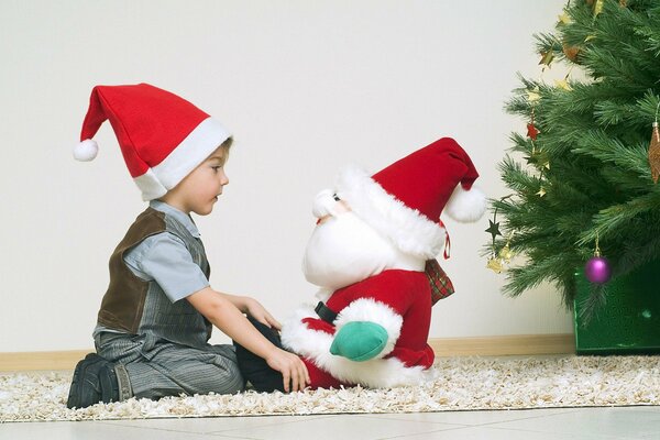 A child looks at a Santa Claus toy