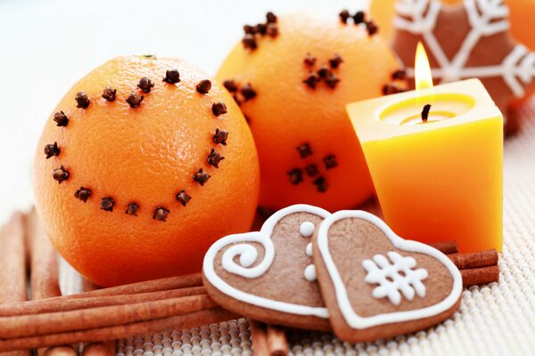 Świąteczne pierniki, pomarańcze, cynamon i płonąca świeca