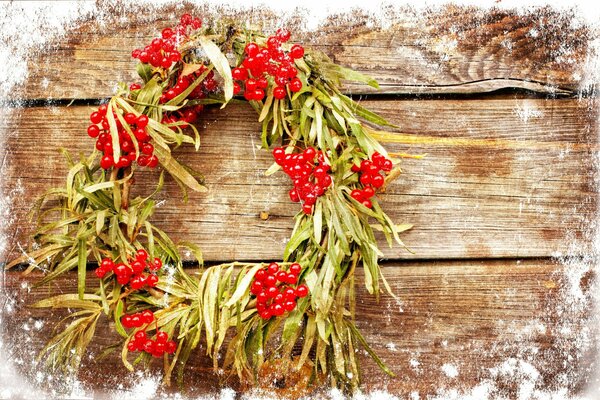 Weihnachtskranz auf einem hölzernen Hintergrund mit einem Rahmen aus eisigem Frost