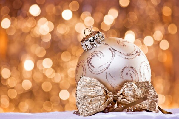 Boule peinte de Noël avec un arc d or sur fond de lumières vives