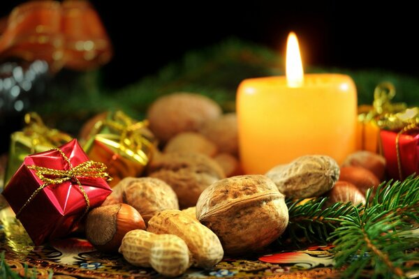 A burning candle with pine nuts and a gift