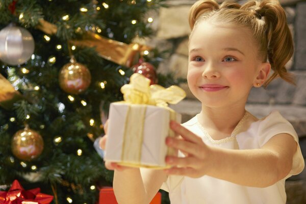 Niña sonriente entrega regalo de año nuevo