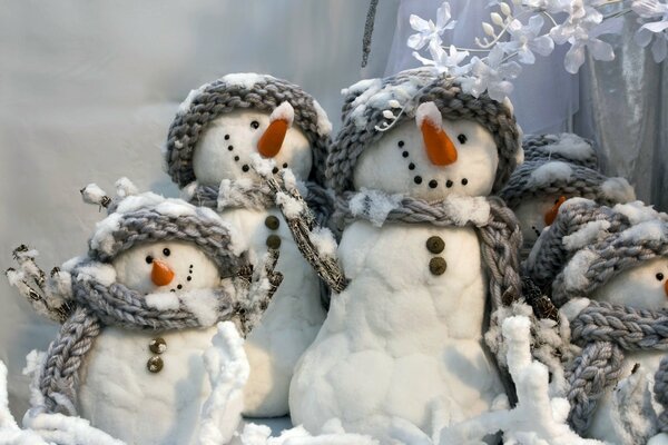 Bonhommes de neige en coton dans des chapeaux et des écharpes tricotés