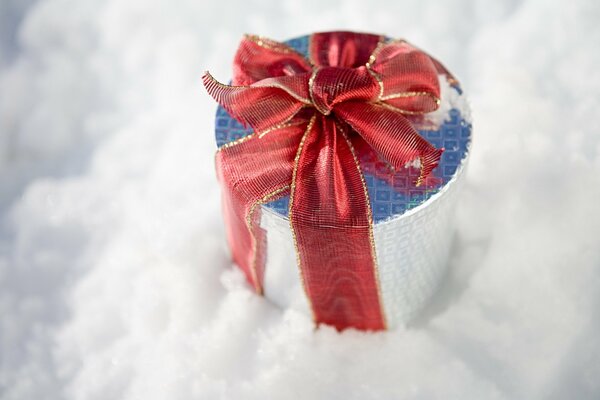 Cadeau de Noël avec un arc rouge dans la neige