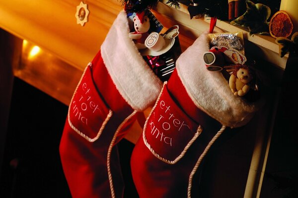 Two socks on the fireplace with gifts