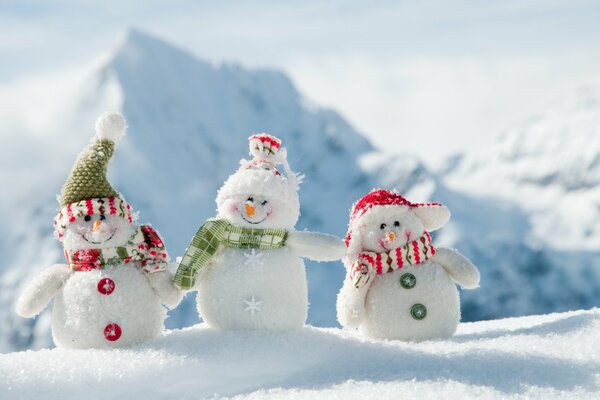 Snowman figures on the background of mountains and snow