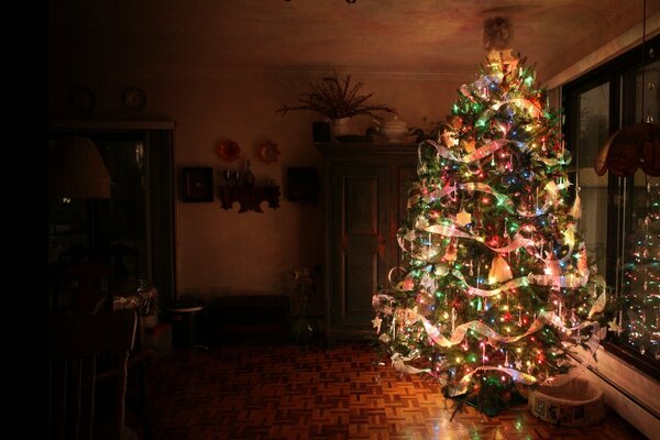 Il fait nuit. Arbre de Noël avec des guirlandes allumées dans l appartement