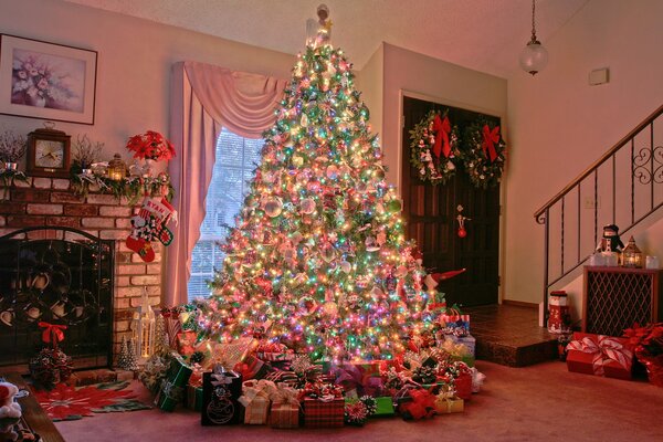 A Christmas tree near the stairs far from the door in the house