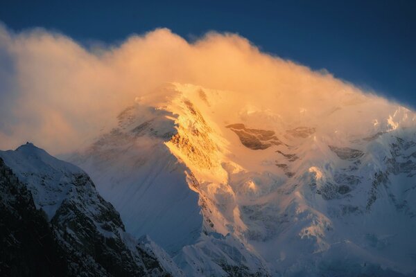 Sommet de la montagne enneigée dans le brouillard