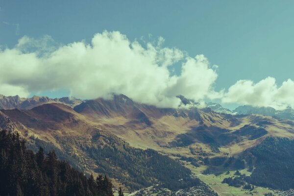 The cloud is like a pillow on top of a mountain