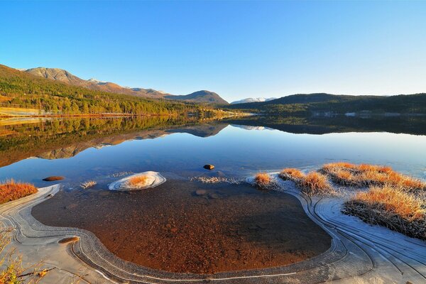 The quiet lake is covered with the first people