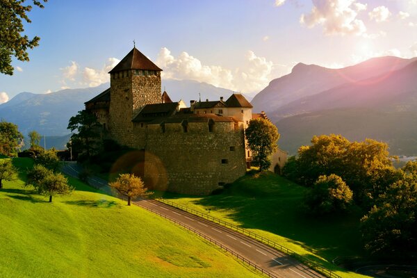 Castello sulla strada nelle Alpi sullo sfondo delle montagne