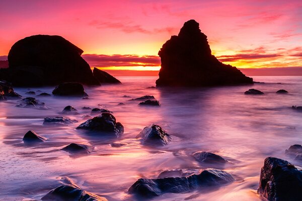 Hermosa puesta de sol en la orilla con piedras