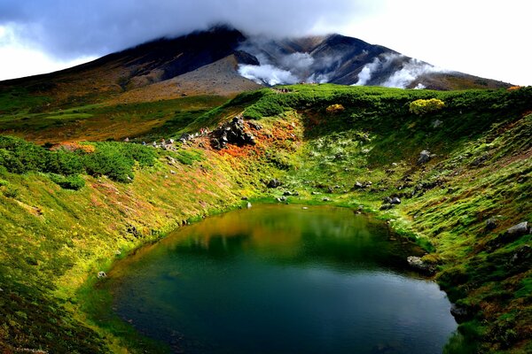 Lago intorno al quale è un campo colorato con montagne