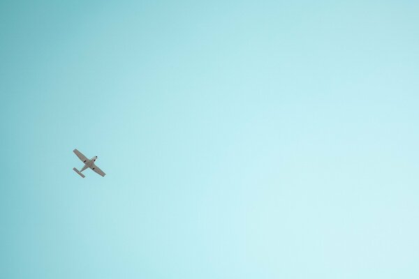 Ein Flugzeug, das im türkisfarbenen Himmel fliegt