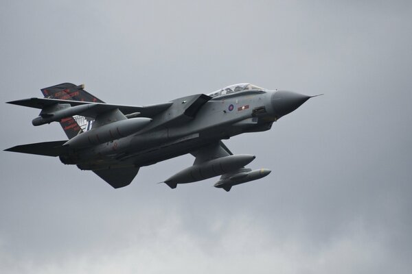 Tornado military fighter bomber flies in the gray sky