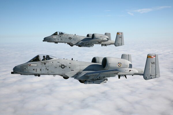 A pair of a-10 attack aircraft, thunderbolt II in the sky above the clouds