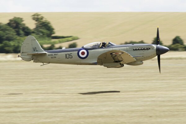 British fighter aircraft of the Second World War flies over the field