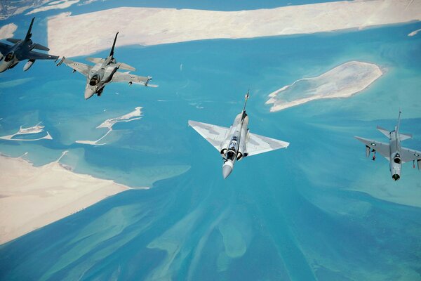 Cuatro aviones de combate vuelan sobre el mar
