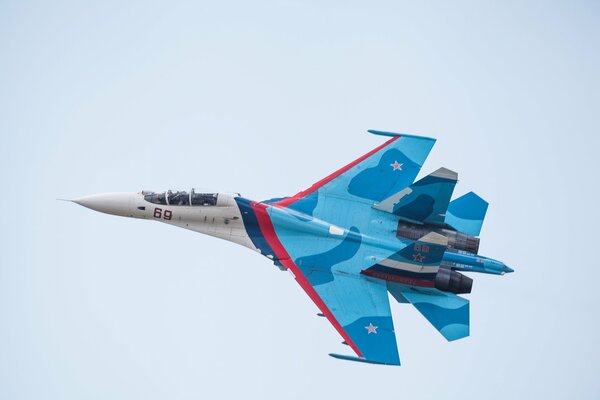 The Su-27 fighter is flying in the blue sky