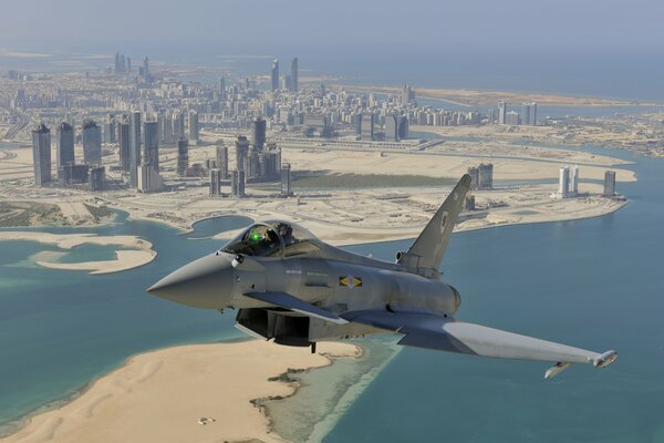 A fighter jet flying over the city of Dubai