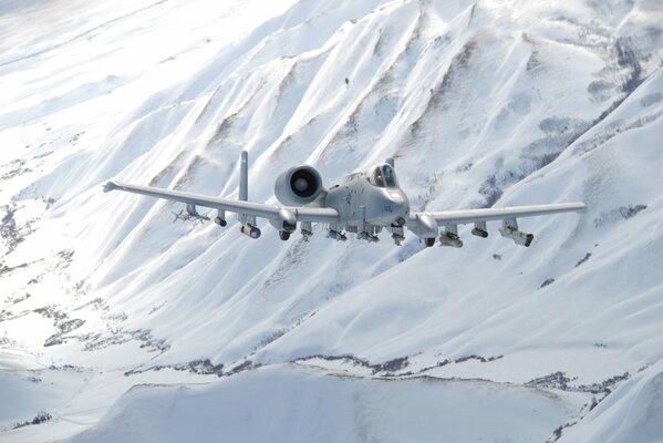 Avión de ataque Thunderbolt II sobrevuela montañas nevadas