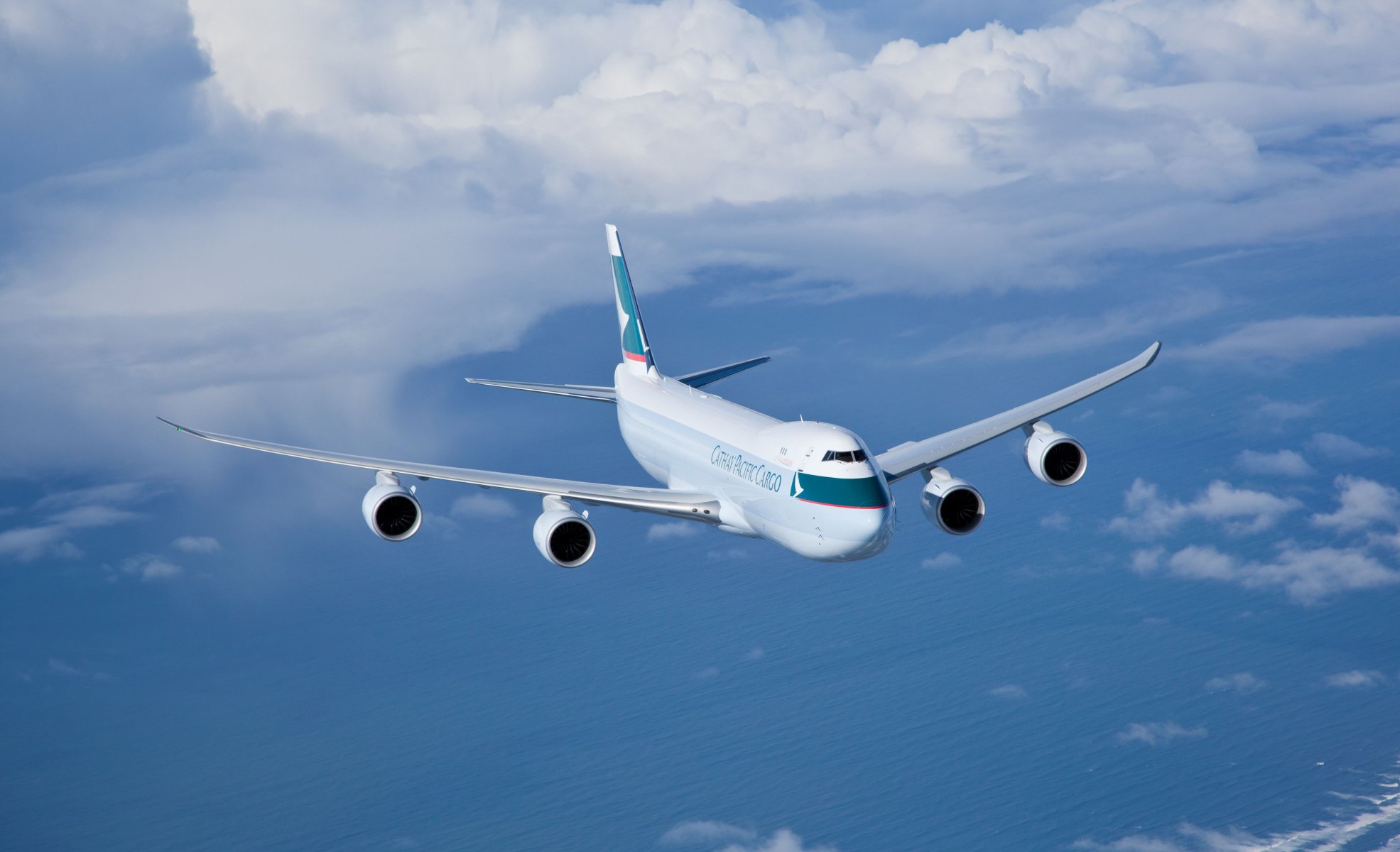 cathay pacific cargo flight flying in the air sky clouds sea aviation