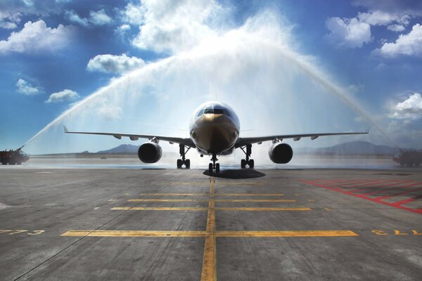 Quindi i camion dei pompieri arrivano aereo di linea passeggeri Airbus A330. Primo imbarco nel nuovo aeroporto