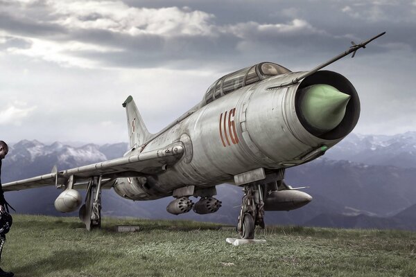 A man stands at the Su-7 military aircraft