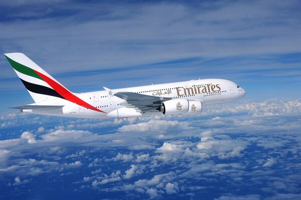 Airbus der Firma emirates fliegt über den Wolken