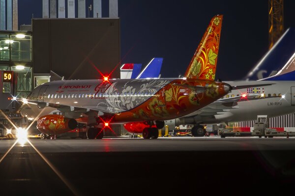 The plane is painted in the Russian style and stands at the airport