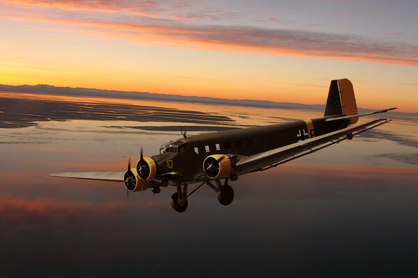 Deutscher dreimotoriger Junkers im Hintergrund des Sonnenuntergangs