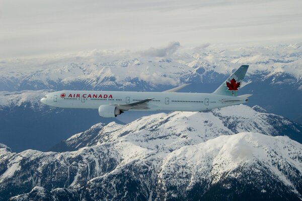 Boing 777 de Air Canada en el cielo sobre las montañas