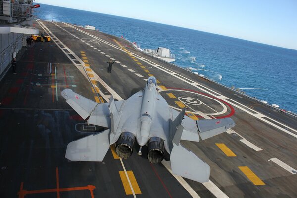 The fighter plane is on an aircraft carrier