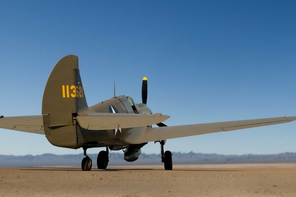 Avión en el desierto en medio de montañas en la distancia