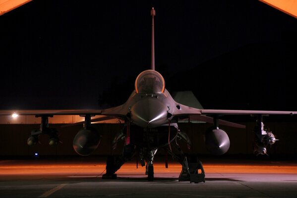 Un avión de combate f - 16 se encuentra en la pista