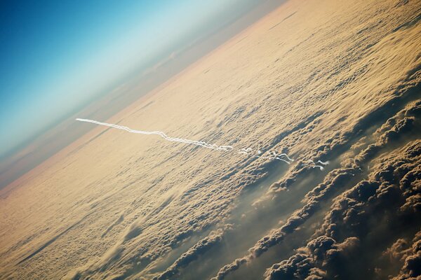 Traccia da aereo nel cielo sopra le nuvole