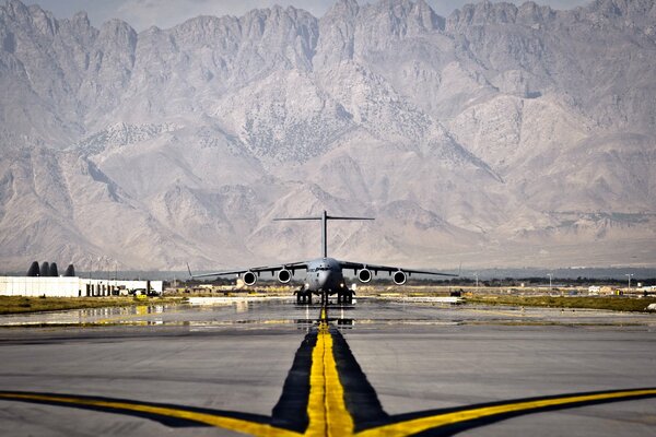 A plane on the runway against the background of mountains