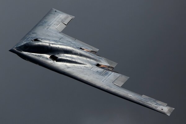 Das Flugzeug b - 2 spirit fliegt vor grauem Hintergrund