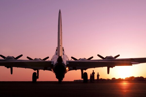 El avión se encuentra en el aeródromo en medio de la puesta del sol