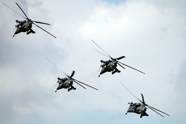 Four helicopters flying in the sky