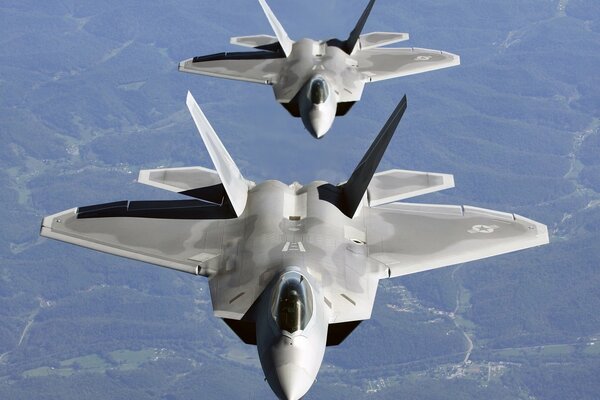 A pair of f - 22 aircraft in the air